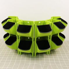 a group of green chairs sitting next to each other on a tiled floor in front of a white wall