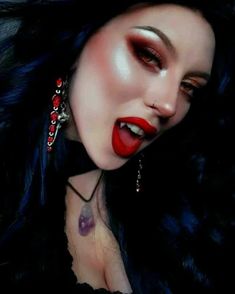 a woman with black hair and red lipstick on her face is posing for the camera