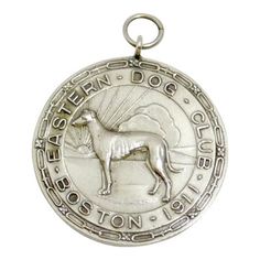 a silver medal with a dog on it