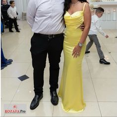 a man and woman in formal wear standing next to each other on the dance floor