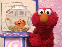 the sesame street character is next to a fish bowl