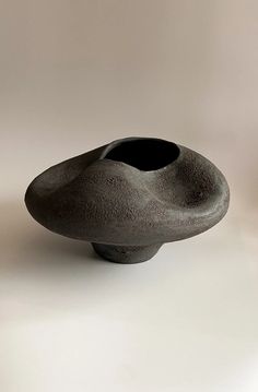 a black vase sitting on top of a white table