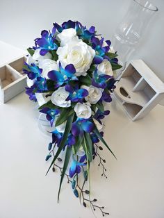 a bouquet of flowers sitting on top of a table next to an empty box and vase