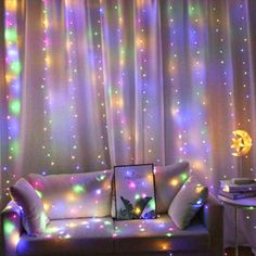 a living room filled with furniture and colorful lights on the wall above it's windows