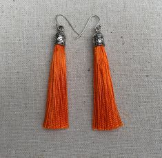 "Chic orange tassel earrings! They would add a pop of color to any outfit for any occasion. Dress them up or down. They are timeless and versatile. They are lightweight, fun and unique! The tassels measure 2 1/8\" long by 1/4\" wide. They hang from simple silver ear wire hooks. Overall drop length is about 2 1/4\". Metal is allergy free plated silver. These are my latest creation! I have them available in many colors! Find them all under the category tassel earrings in my shop. Thanks for stoppi Lover Earrings, Autumn Earrings, Orange Jewelry, Boho Hoop Earrings, Silver Chandelier Earrings, Boho Hippie Chic, Orange Earrings, Fall Earrings, Unique Jewelry Designs