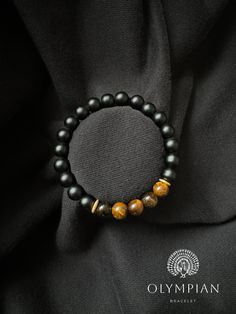 Elevate your style with this eye-catching bracelet that pairs the sleek elegance of matte black onyx with the warm, dynamic hues of tiger eye. The matte black onyx beads create a contemporary aesthetic, while the tiger eye stones add a vibrant touch, making this piece both stylish and meaningful. Materials: Matte Black Onyx: Featuring a smooth, matte finish, black onyx symbolizes strength, resilience, and protection. Its rich black color adds a sophisticated element to any outfit. Tiger Eye: Wit Black Diamond Wedding Rings, Black Onyx Bracelet, Bracelet Bead, Tiger Eye Bracelet, Onyx Bracelet, Tiger Eye Beads, Wedding Jewelry Bracelets, Onyx Bead, Tiger Eye Stone