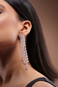 Adorn yourself with elegance with these exquisite long Diamond danglers, featuring three strings of shimmering faux diamonds against a pristine white finish. A true statement piece, they exude sophistication and add a touch of ravishing allure to any ensemble, perfect for elevating your look with timeless charm. Finish: Rhodium Material: Brass, Faux Diamonds Color: White Size: One Size Closure Type: Push Back Box Contains: 1 Pair of Earrings Luxury Cutdana Danglers For Wedding, Silver Danglers For Reception, Danglers Earrings Diamond, Long Diamond Earrings, Diamond Danglers, Hand Jewelry Rings, Chain Braid, Diamond Earrings For Women, Artificial Jewelry