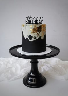 a black and white birthday cake with gold sprinkles