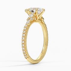 a yellow gold engagement ring with an oval cut diamond on the center and side stones