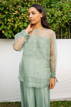 Green silk organza 3D hand embroidered shirt with floral motifs. Comes with an inner.
Components:2
Pattern:Embroidered
Type of Work:Hand Embroidered
Neckline:Round
Sleeve Type:Puffed sleeves
Fabric:Shirt: 100% Silk Organza, Inner: Viscose Tabby
Color:Green
Other Details:
Note: The pant worn by model is not for sale.
Occasion:Party,Work - Aza Fashions Elegant Tissue Silk Blouse With Floral Embroidery, Silk Chiffon Tops With Sheer Sleeves For Parties, Embroidered Organza Blouse For Wedding, Party Tops With Sheer Sleeves In Silk Chiffon, Party Silk Chiffon Tops With Sheer Sleeves, Wedding Blouse In Organza With Chikankari Embroidery, Wedding Organza Blouse With Chikankari Embroidery, Organza Blouse With Chikankari Embroidery For Party, Eid Sheer Dupatta Cotton Silk Blouse