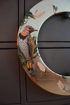 a bird painted on the side of a door frame with flowers and leaves around it