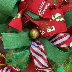 a red and green christmas wreath with a gold ornament