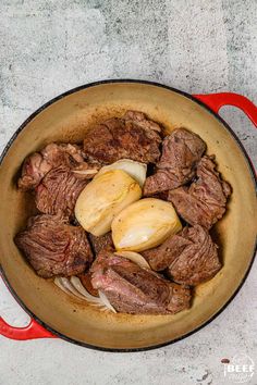 steak and onions cooking in a red pot