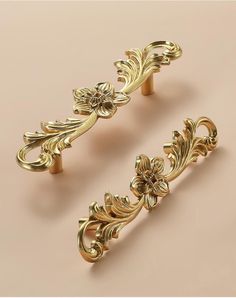 two golden handles with flowers and leaves on each handle, one in the shape of a flower