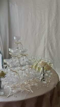 a table topped with lots of glasses filled with champagne and flowers on top of it