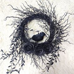 a black bird sitting on top of a wreath