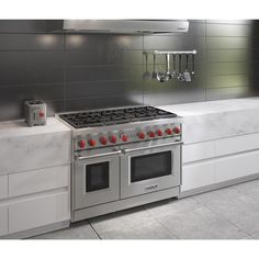 a stove top oven sitting inside of a kitchen next to a counter with utensils on it