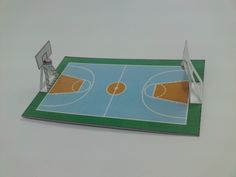 a paper model of a basketball court with a goal in the middle and an empty basket