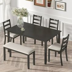 a dining room table with four chairs and a bench