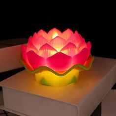 a lit up flower sitting on top of a table