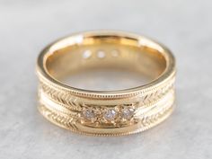 This engraved band is of a perfect heft and shape to feel soft and pleasant on the finger. It is both pretty and sophisticated, and it would be a great wedding or stacking band for a woman who wants a little extra sparkle but works with her hands. Metal: 18K Yellow Gold Gem: 12 Diamonds totaling .36 Carats, F in Color, VVS in Clarity Width of Band: 6.5 mm Height off Finger: 1.9 mm Ring Size: 6 Marks: "AA18K" Stamped on the inside band Wedding Ring With Single Cut Diamonds And Thick Band, Fine Jewelry 14k Gold Diamond Ring With Decorative Band, 14k Gold Diamond Ring With Decorative Band, 14k Gold Bands With Diamond Accents, Heirloom Diamond Stackable Bands, Heirloom Style Round Promise Band, Yellow Gold Diamond Jewelry With Decorative Band, Yellow Gold Diamond Ring With Decorative Band, Luxury 14k Gold Wedding Band With Decorative Details