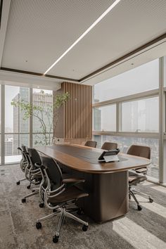 an empty conference room with chairs and a large table in front of a window overlooking the city