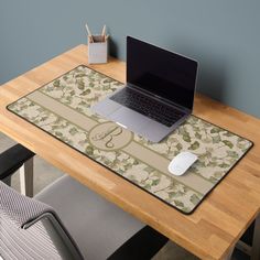 a laptop computer sitting on top of a wooden desk next to a mouse and keyboard