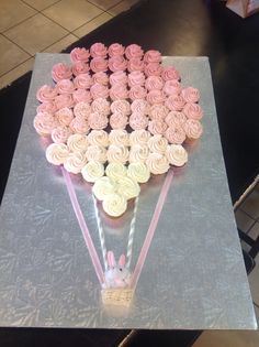 cupcakes are arranged in the shape of a heart on top of a table