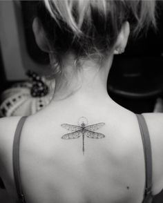 a woman's back tattoo with a dragonfly on her left shoulder and chest