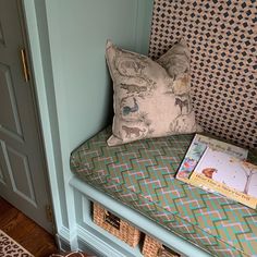 there is a book on the bench next to the bookshelf in the room