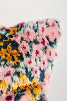 a multicolored furry pillow on a white background