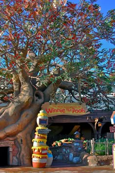 a large tree with lots of fruit on it's branches in front of a store