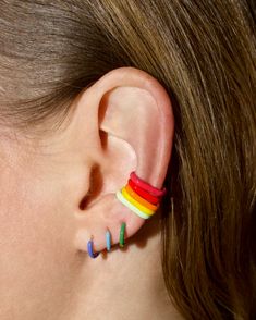 a woman wearing rainbow colored ear piercings