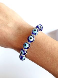 Evil Eye Charms are believed to bring good luck. Evil eye beads are made of glass. Evil eye beaded bracelet is stretchy so this elastic bracelet comfortably fits on any wrists. There are 16 glass evil eye beads on the bracelet. Bracelet color options: Blue evil eye bracelet Light blue evil eye bracelet Red evil eye bracelet Multicolor evil eye bracelet Evil eye charm is over 5000 years old. It is found in all major religions and cultures. Blue evil eye or lucky evil eye is a Mediterranean amulet Blue Crystal Bracelet With Colorful Beads, Blue Evil Eye Bracelet With Round Beads, Blue Beaded Bracelets With Evil Eye, Blue Evil Eye Round Beaded Bracelets, Blue Spiritual Bracelets With Large Beads, Blue Spiritual Stretch Bracelet With Large Beads, Blue Spiritual Evil Eye Bracelet With Colorful Beads, Spiritual Blue Stretch Bracelet With Large Beads, Spiritual Blue Evil Eye Bracelet With Colorful Beads