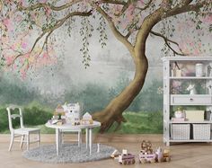 a child's room with a tree mural and toys on the floor in front of it