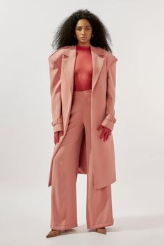 Pink longline lapel collar trench coat. Paired with a sheer bodysuit top and flared pant. - Aza Fashions Chic Long Sleeve Pantsuit In A Solid Color, Chic Solid Color Long Sleeve Pantsuit, Chic Long Sleeve Pantsuit For Fall, Chic Tailored Pantsuit With Lapel Collar, Evening Pantsuit With Lapel Collar For Fall, Fall Evening Pantsuit With Lapel Collar, Spring Formal Pantsuit With Belted Cuffs, Chic Evening Pantsuit With Single Breasted Detail, Chic Evening Pantsuit For Fall