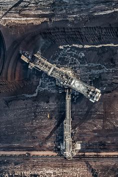 an aerial view of a large crane in the middle of a desert area with dirt and rocks