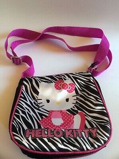 a hello kitty purse with a pink bow on the front and zebra print, it has a