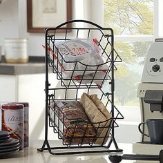 a coffee maker sitting on top of a counter next to a basket filled with food