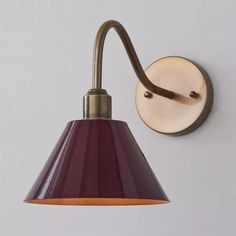 a wall light with a purple shade on it's side and a white background