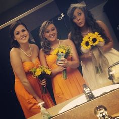 three bridesmaids are standing in front of the bathroom mirror with sunflowers