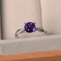 This ring features a 7*7 mm round cut natural amethyst ,and sterling silver finished with rhodium. Customization is available. It is made by hand, and it will take about 7 days to finish the ring after your payment is completed. Main stone: natural amethyst Main stone weight: Approx 1.25 ct Metal type: sterling silver finished with rhodium Accent stone: cz Customization is available, I also can make it with 14k solid gold (white or yellow or rose) and diamond accent stone, just feel free to cont Amethyst Rings, Punk Rock Jewelry, Original Engagement Rings, Gifts For Mother, Green Amethyst Ring, London Blue Topaz Ring, Twisted Band, Purple Band, February Birthstone