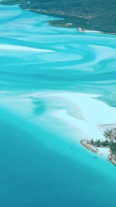 an aerial view of the blue water and white sand beach in the middle of the ocean