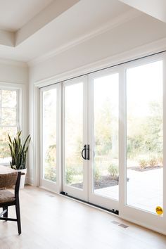 a living room filled with furniture and lots of glass doors leading to an outside patio