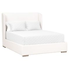 a white bed with two pillows on top of it and a night stand underneath the bed