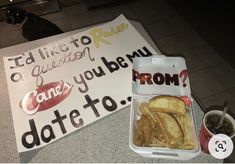 a plastic container filled with french fries next to a sign