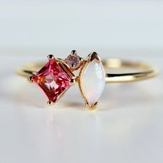 This beautiful, handmade unique cluster ring was made of 14k gold band, 14k gold prong settings. It's perfect as engagement ring or family birthstone statement piece. DETAILS ABOUT THE RING, MATERIAL AND STONES * 14k 1.3mm solid gold band and prongs. * 4x4mm princess cut natural pink tourmaline center stone * 6x3mm marquise cut real Australian opal * 1.5mm natural diamond ( 0.015 ct. weight) GH color SI clarity This ring can be personalized with the different birtstones. RING SIZE : US 7 READY TO SHIP! It can be resized in a week. ** All our raw materials are sourced from US-based companies for the quality and safety of our handmade products. *** This ring is handcrafted for you in our local studio in Redlands, California. We are a small workshop which specializes on handmade jewelry. *** 14k Gold Birthstone Cluster Ring, 14k Gold Cluster Ring With Birthstone, 14k Gold Cluster Sapphire Promise Ring, Pink 14k Gold Cluster Ring With Gemstone, Cluster Yellow Gold Birthstone Ring Gift, Birthstone Cluster Ring With Accent Stones As Gift, Yellow Gold Cluster Birthstone Ring Gift, Birthstone Cluster Ring Gift, 14k Gold Cluster Birthstone Ring