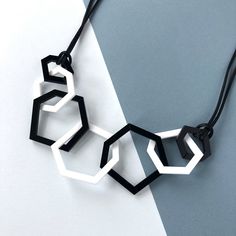 Stylish black and white modern acrylic geometric stylish necklace which is perfect for the woman who likes contemporary style.  My necklaces are light and eay to wear and will give your favourite outfit an instant pop of colour. This seven link necklace is my 'between' size, not as dramatic as my twelve link necklace and more of a statement than the three link one. It is mid-length and measures 26 inches long and hangs 13.5 inches from the clasp to the bottom link.  Three sizes of laser cut geom Geometric Shapes Jewellery, Luxury Modern Black Necklace, Modern Black Necklace With Square Pendant, Unique Black Geometric Jewelry, Modern Geometric Metal Necklace, Modern Black Geometric Necklace, White Runway, Necklace Packaging, Black Tissue Paper