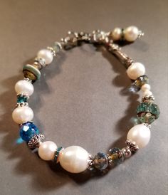 Lovely freshwater pearls contrast beautifully with teal Czech glass and Swarovski crystal beads. Rounded lobster clasp. Elegant Turquoise Czech Glass Beaded Bracelets, Teal Glass, Swarovski Crystal Beads, Glass Bracelet, Pearl Shell, Czech Glass, Arm Band, Swarovski Crystal, Crystal Beads