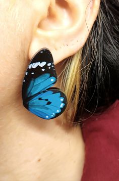 a close up of a person's ear with a butterfly on it